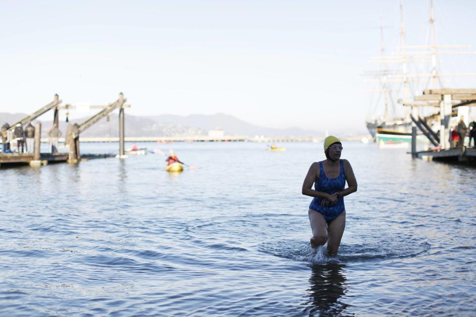 Swimmer with the South End Rowing Club exits the water at the Aquatic Park after finishing the annual