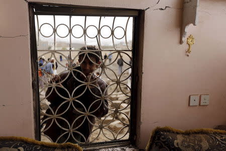 A boy looks through the window grills of a house that was damaged by a Saudi-led air strike in Yemen's capital Sanaa August 26, 2015. REUTERS/Khaled Abdullah