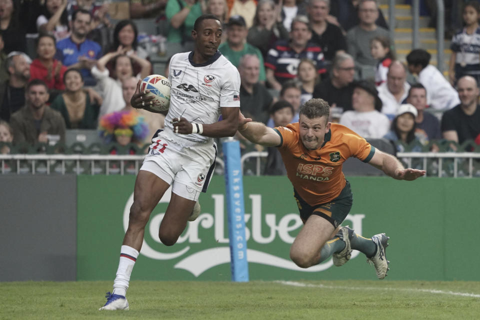Perry Baker of the United States runs to score a try as he breaks away from Australia's Hayden Sargeant during the second day of the Hong Kong Sevens rugby tournament in Hong Kong, Saturday, April 1, 2023. (AP Photo/Anthony Kwan)