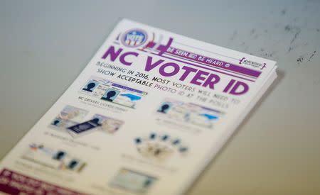 A pile of government pamphlets explaining North Carolina's controversial "Voter ID" law sits on table at a polling station as the law goes into effect for the state's presidential primary in Charlotte, North Carolina, U.S. on March 15, 2016. REUTERS/Chris Keane/File Photo