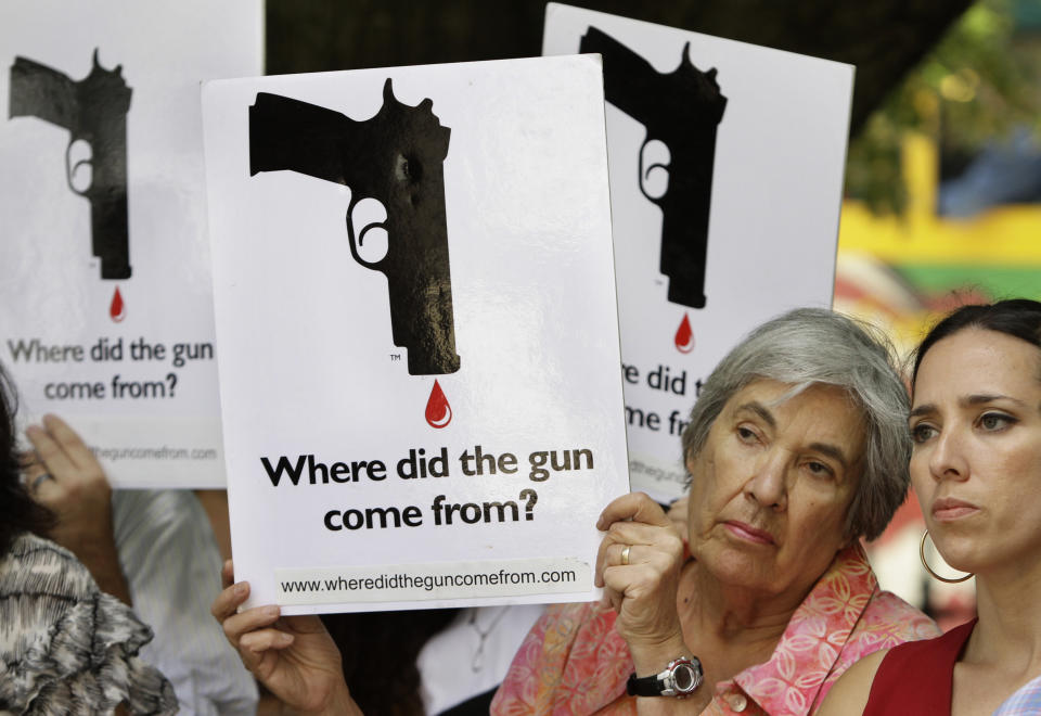FILE - Carol Streiff, of Boston, second from right, displays a placard as Mass. State Sen. Sonia Chang-Diaz, D-Boston, right, looks on during rally in front of the Statehouse, in Boston, Tuesday, June 15, 2010. The Massachusetts House approved a sweeping gun bill Wednesday, Oct. 18, 2023, aimed at tightening firearm laws, cracking down on unregistered, so-called “ghost guns" and strengthening the state’s assault-style weapons ban. (AP Photo/Steven Senne, File)