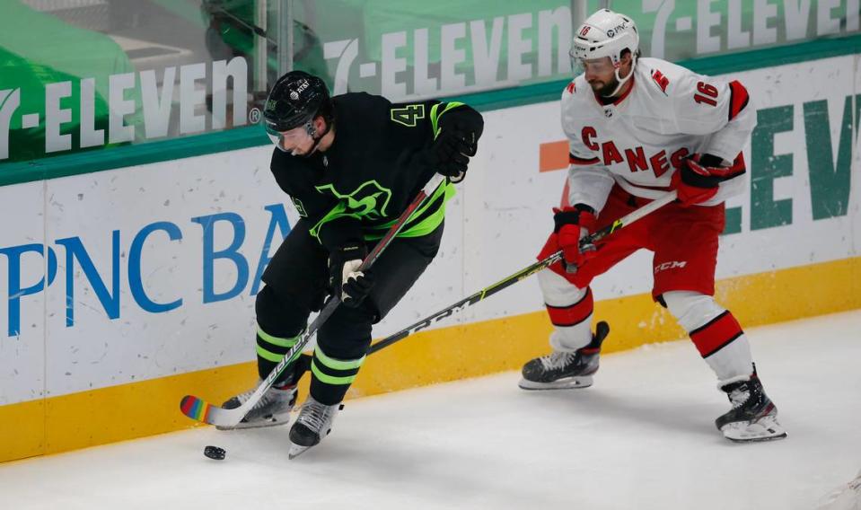 Dallas Stars defenseman Roman Polak, left, and Carolina Hurricanes forward Vincent Trocheck (16) battle for the puck during the third period of an NHL hockey game, Monday, April 26, 2021, in Dallas. Dallas won 4-3 in overtime. (AP Photo/Brandon Wade)