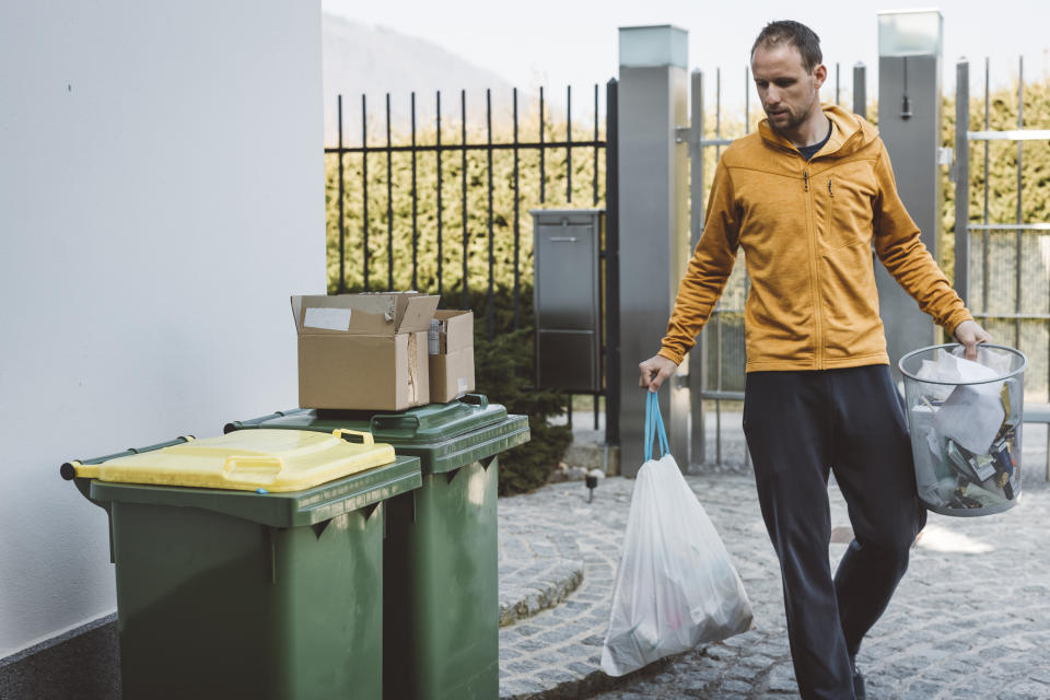 Young caucasian man taking out the trash. Environmental issues. Reuse, reduce, recycle.