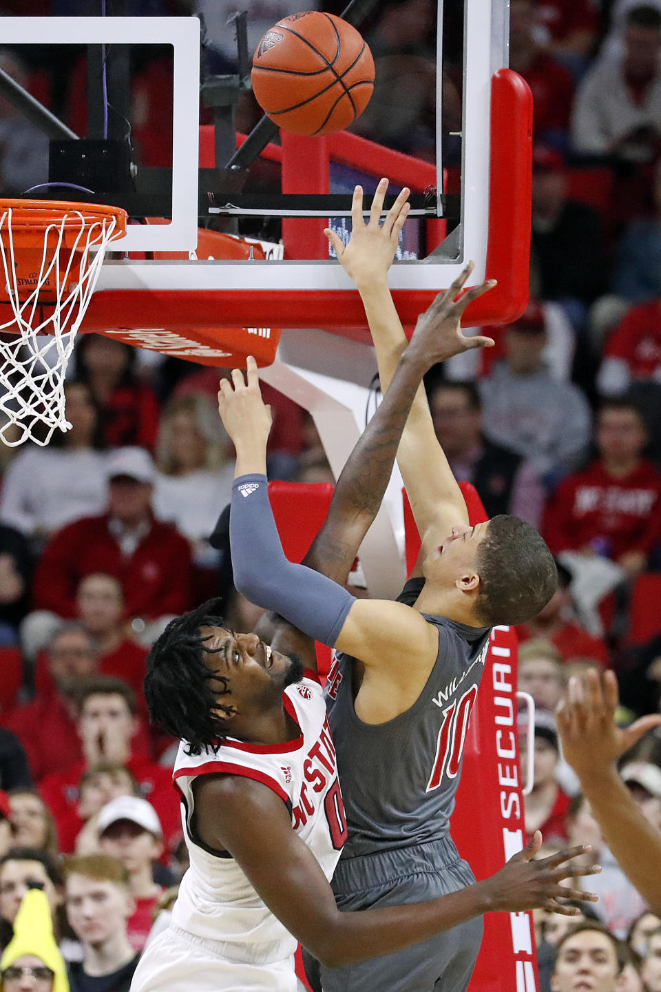 North Carolina State's DJ Funderburk (0) attempts to block the shot of Louisville's Samuell Williamson (10) during the first half of an NCAA college basketball game in Raleigh, N.C., Saturday, Feb. 1, 2020. (AP Photo/Karl B DeBlaker)