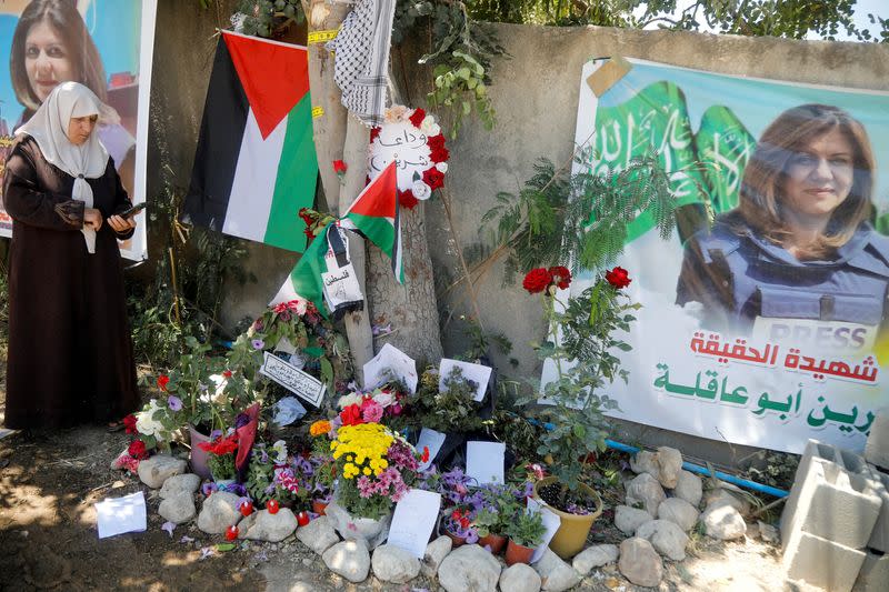 FILE PHOTO: A Palestinian woman takes pictures at the scene where Al Jazeera reporter Shireen Abu Akleh was shot dead during an Israeli raid, in Jenin