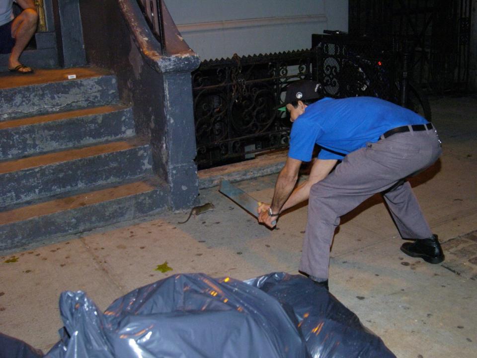 Manuel Rodriquez swings at a rat outside his apartment in 2004.