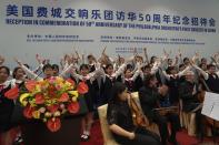 FILE - From left musicians from the Philadelphia Orchestra, Yu-Ting Chen on violin, Philip Kates on violin/viola and John Koen on cello clap after a rehearsal with the Beijing Philharmonic Choir children before a reception to commemorate the 50th anniversary of the Philadelphia Orchestra's first concert in China at the Diaoyutai state guesthouse in Beijing on Nov. 9, 2023. (AP Photo/Ng Han Guan, File)