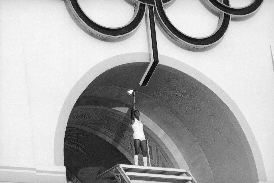 Rafer Johnson, 1960 gold medalist for the decathlon, lights the Olympic torch during the Opening Ceremonies of the 23rd Olympiad in Los Angeles in 1984. (AP Photo)