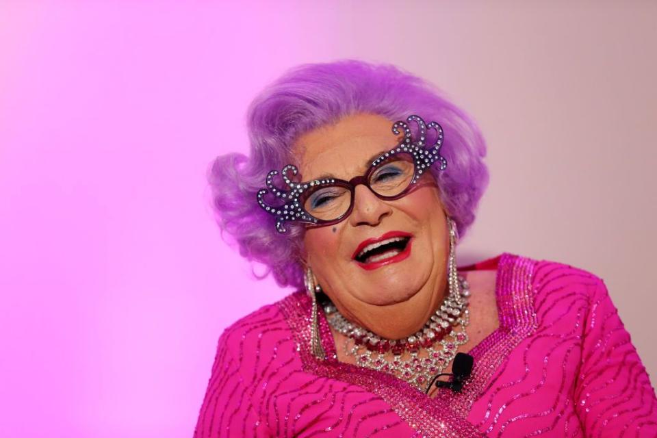 barry humphries as dame edna everage poses during a high tea launch, wearing all pink with funky sunglasses