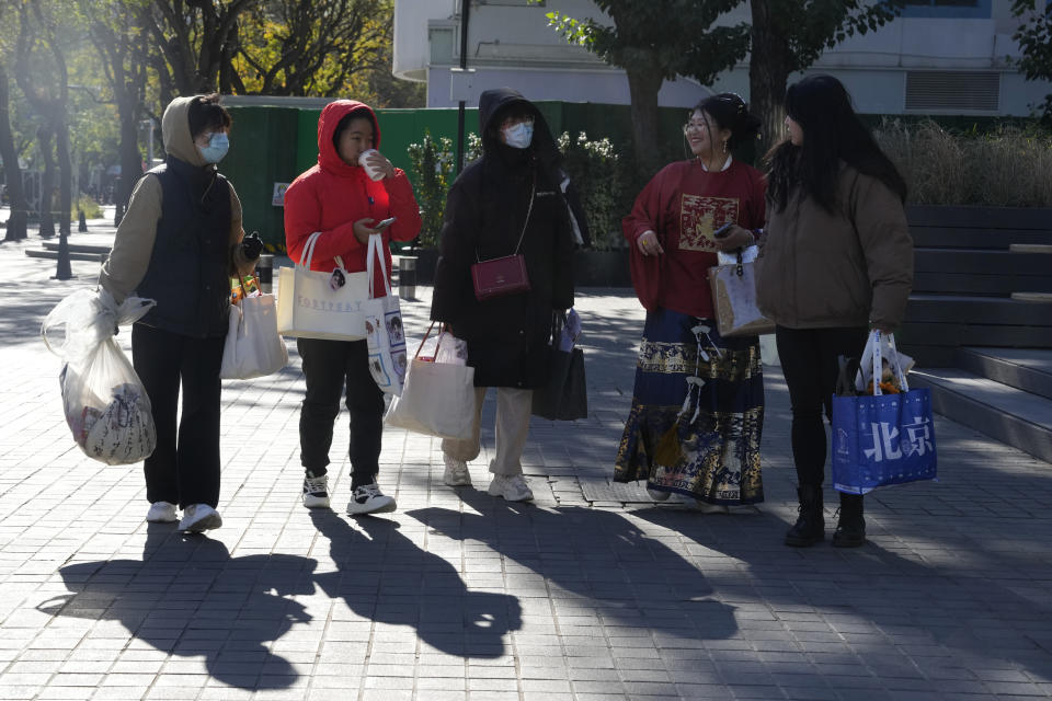 Visitors walk through a mall district in Beijing, Saturday, Nov. 11, 2023. Shoppers in China have been tightening their purse strings, raising questions over how faltering consumer confidence may affect the annual Singles' Day online retail extravaganza. (AP Photo/Ng Han Guan)