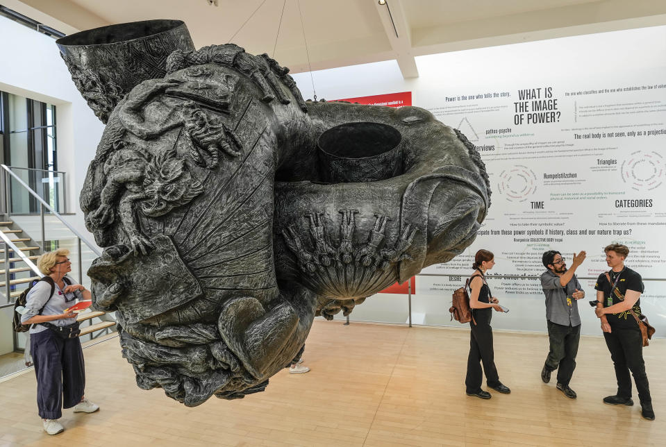 Mexican artist Erick Beltran, 2nd from right, explains his artwork during the press preview of the documenta 15, the world's most significant exhibition of contemporary art, in Kassel, Germany, Wednesday, June 15, 2022. This years documentary is curated by Indonesian artist collective Ruangrupa, every documenta is limited to 100 days of exhibition and takes place every 5 years. (AP Photo/Martin Meissner)