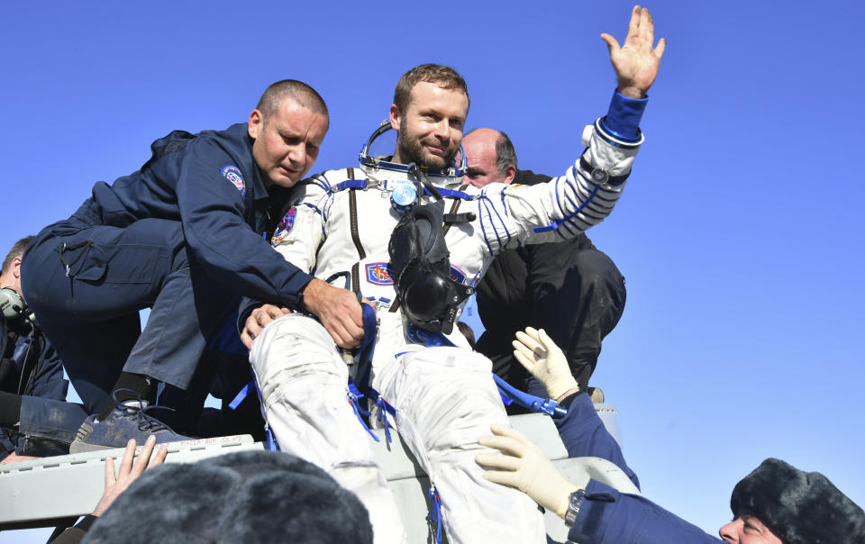 In this photo released by Roscosmos Space Agency, Russian space agency rescue team members help film director Klim Shipenko out from the capsule shortly after the landing of the Russian Soyuz MS-18 space capsule about 150 km (90 miles) south-east of the Kazakh town of Zhezkazgan, Kazakhstan, Sunday, Oct. 17, 2021. The Soyuz MS-18 capsule landed upright in the steppes of Kazakhstan on Sunday with cosmonaut Oleg Novitskiy, actress Yulia Peresild and film director Klim Shipenko aboard after a 3 1/2-hour trip from the International Space Station. (Roscosmos Space Agency via AP)