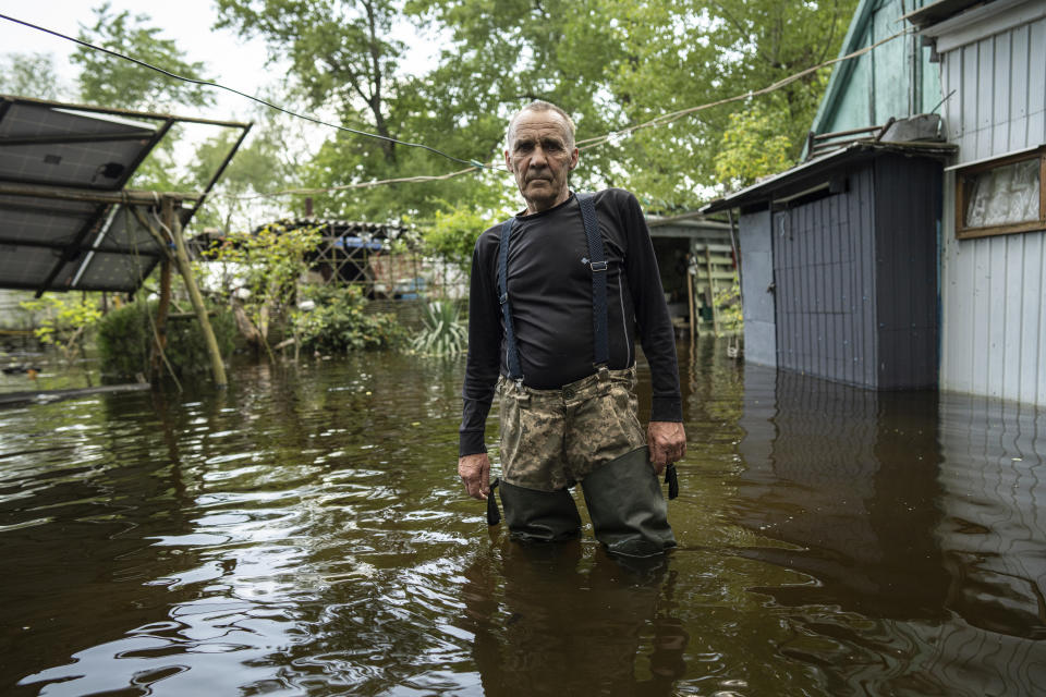 Ihor Medyunov, a local hunter stands in the courtyard of his flooded house in the island of Kakhovka reservoir on Dnipro river near Lysohirka, Ukraine, Thursday, May 18, 2023. Damage that has gone unrepaired for months at a Russian-occupied dam is causing dangerously high water levels along a reservoir in southern Ukraine. (AP Photo/Evgeniy Maloletka)