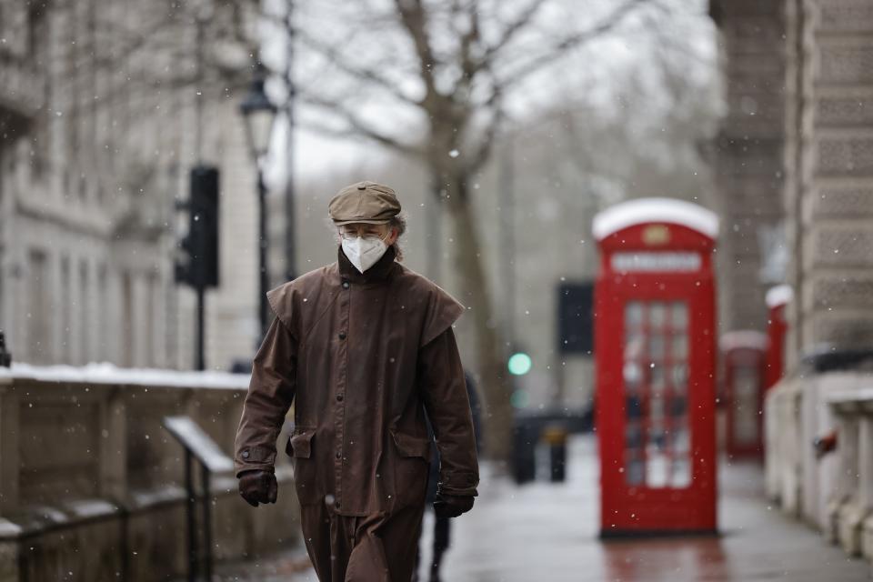 TOPSHOT - A man wearing a face mask because of the coronavirus pandemic walks in the street in London on February 8, 2021. (Photo by Tolga Akmen / AFP) (Photo by TOLGA AKMEN/AFP via Getty Images)