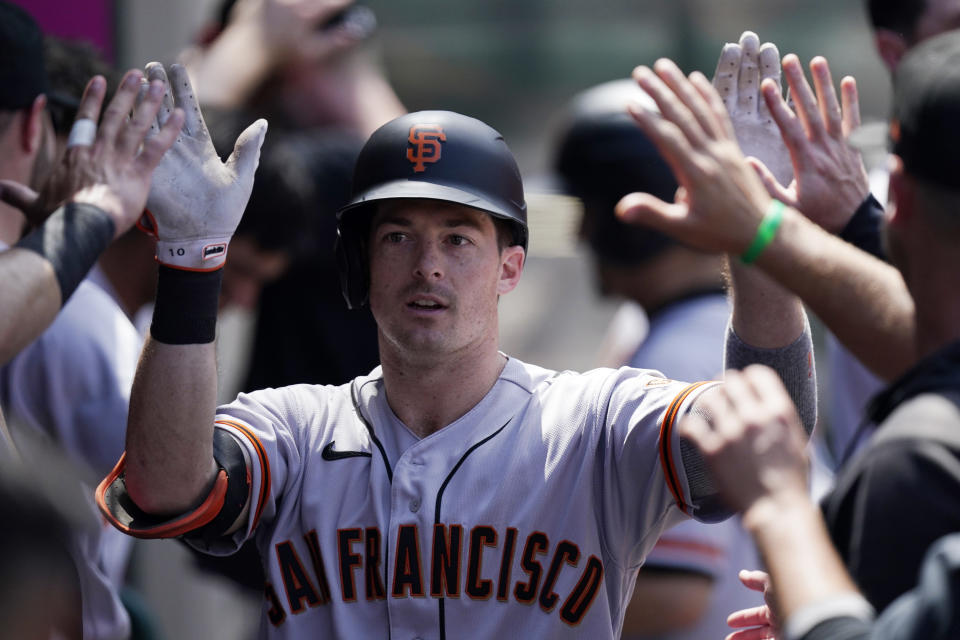 San Francisco Giants' Mike Yastrzemski is congratulated by teammates in the dugout after hitting a solo home run during the fifth inning of a baseball game against the Los Angeles Angels Wednesday, June 23, 2021, in Anaheim, Calif. (AP Photo/Mark J. Terrill)