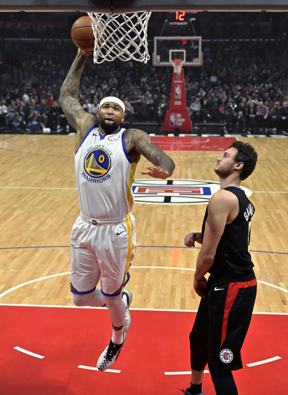Golden State Warriors center DeMarcus Cousins, left, goes up for a dunk as Los Angeles Clippers forward Danilo Gallinari watches during the first half of an NBA basketball game Friday, Jan. 18, 2019, in Los Angeles. (AP Photo/Mark J. Terrill)
