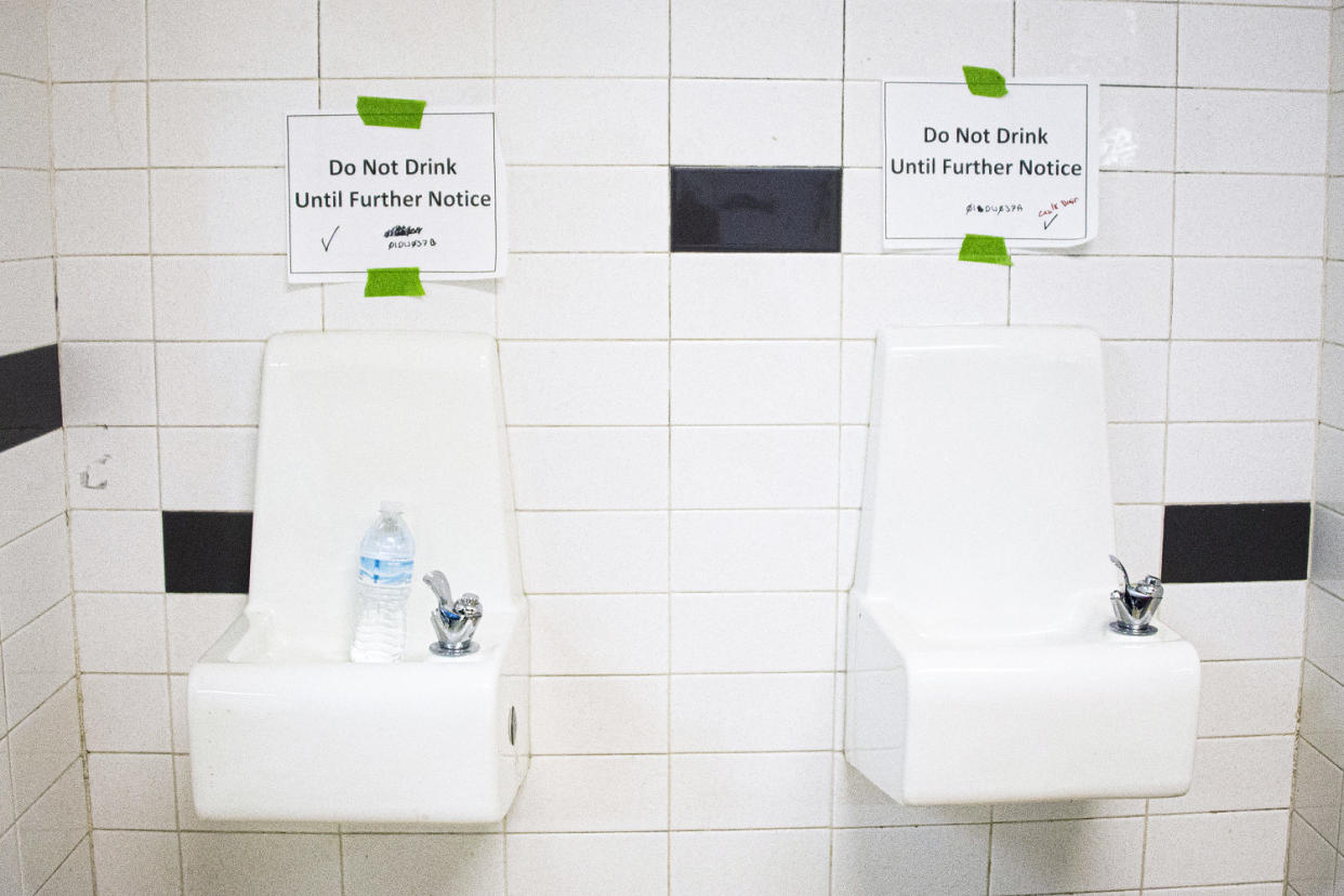 Placards posted above water fountains. (Jim Watson / AFP via Getty Images file)