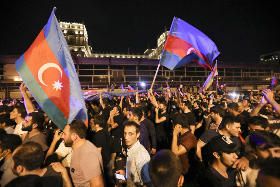 People carry Azerbaijn's national flags as they rally in support of Azerbeijan's Army in Baku, Azerbaijan, Tuesday, July 14, 2020. Skirmishes on the volatile Armenia-Azerbaijan border escalated Tuesday, marking the most serious outbreak of hostilities between the neighbors since the fighting in 2016. (AP Photo/Aziz Karimov)