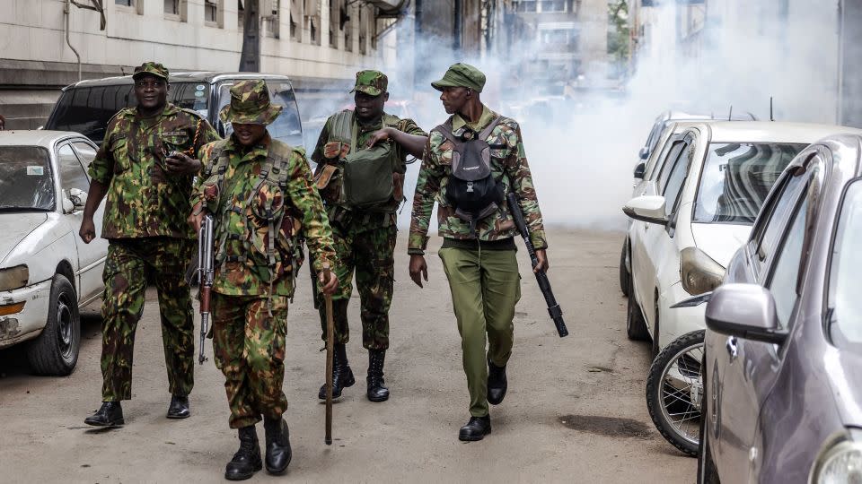 Kenyan police officers walk away from a street covered in tear gas during a demonstration against tax hikes in downtown Nairobi on June 18, 2024. - Luis Tato/AFP/Getty Images