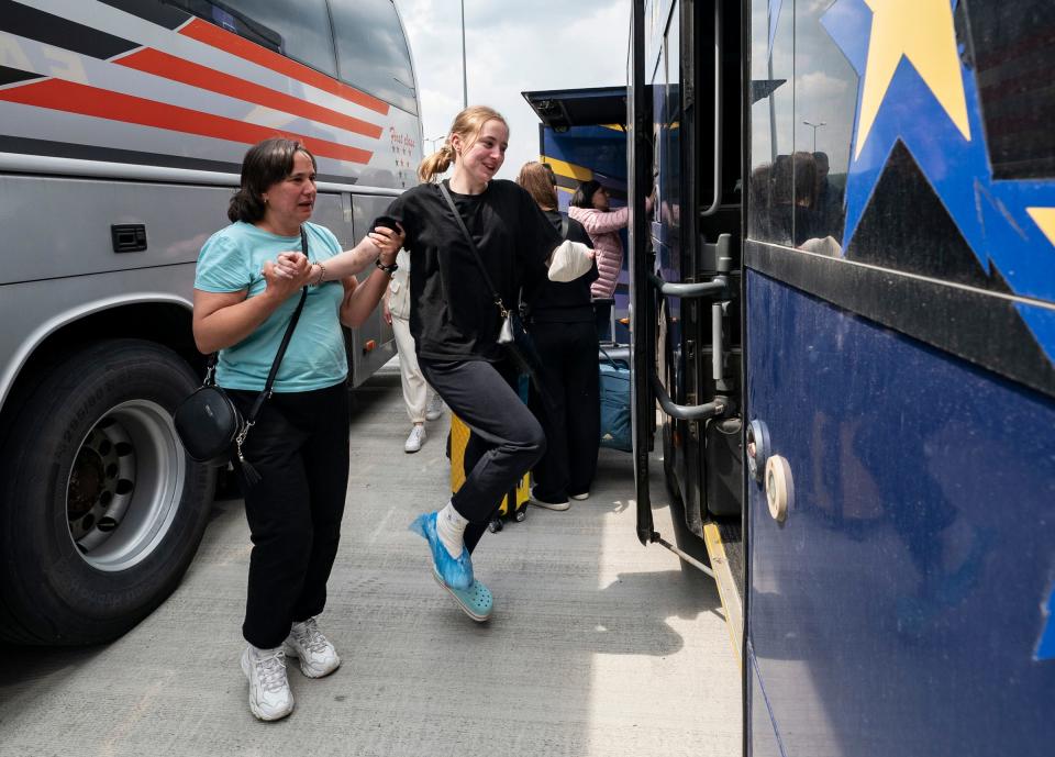 Olena Katasova, left, helps her daughter Mariia Ovdiienko, 16, hop from their bus from Poland to their connecting bus at the Ukraine border on Saturday, May 20, 2023. Ovdiienko had a surgery performed by Doctors Collaborating to Help Children earlier that helped separate her fingers and toes from a congenital abnormality that prohibited all of her digits to move Independent of one another. 