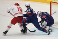 Poland's Pawel Zygmunt, left, tries to score as Unted States' Jake Sanderson, center, blocks him during the preliminary round match between Poland and United States at the Ice Hockey World Championships in Ostrava, Czech Republic, Friday, May 17, 2024. (AP Photo/Darko Vojinovic)
