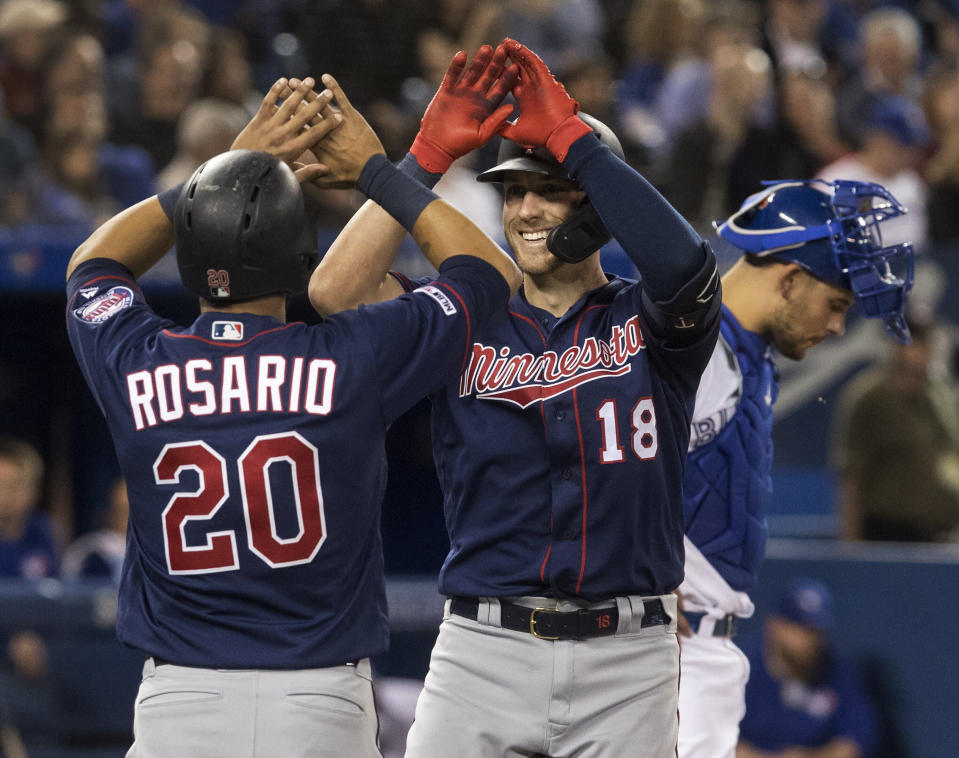 Minnesota Twins' Mitch Garver (18) high-fives teammate Eddie Rosario (20) after Garver hit a two-run home run against the Toronto Blue Jays in the sixth inning of a baseball game in Toronto, Tuesday, May 7, 2019. (Fred Thornhill/The Canadian Press via AP)