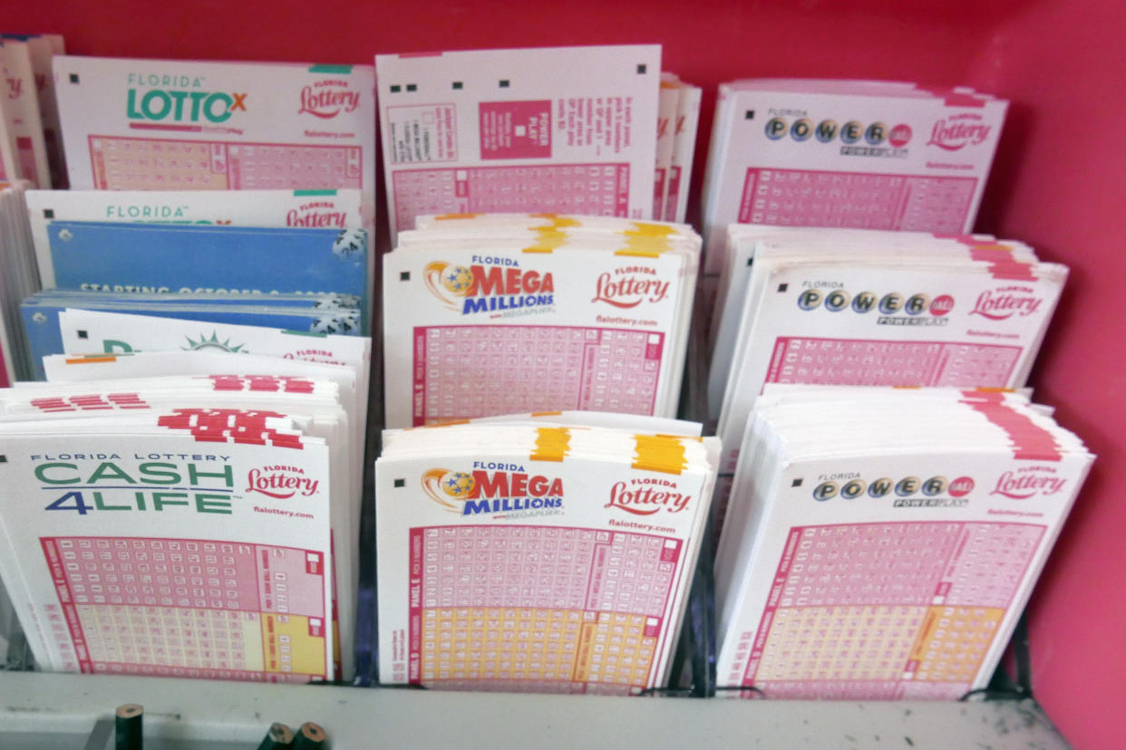 Mega Millions lottery tickets, center, and Power Ball tickets, right, are seen with other lottery tickets at a store in Orlando, Fla. (AP Photo/John Raoux)