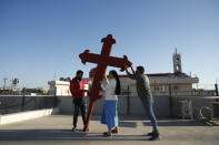 Iraqi Christians place a cross on a church in Qaraqosh, Iraq, Monday, Feb. 22, 2021. Iraq was estimated to have more than 1 million Christians before the 2003 U.S.-led invasion that toppled dictator Saddam Hussein. Now, church officials estimate only few hundred remain within Iraq borders. The rest are scattered across the globe, resettling in far-flung places like Australia, Canada and Sweden as well as neighboring countries. (AP Photo/Hadi Mizban)