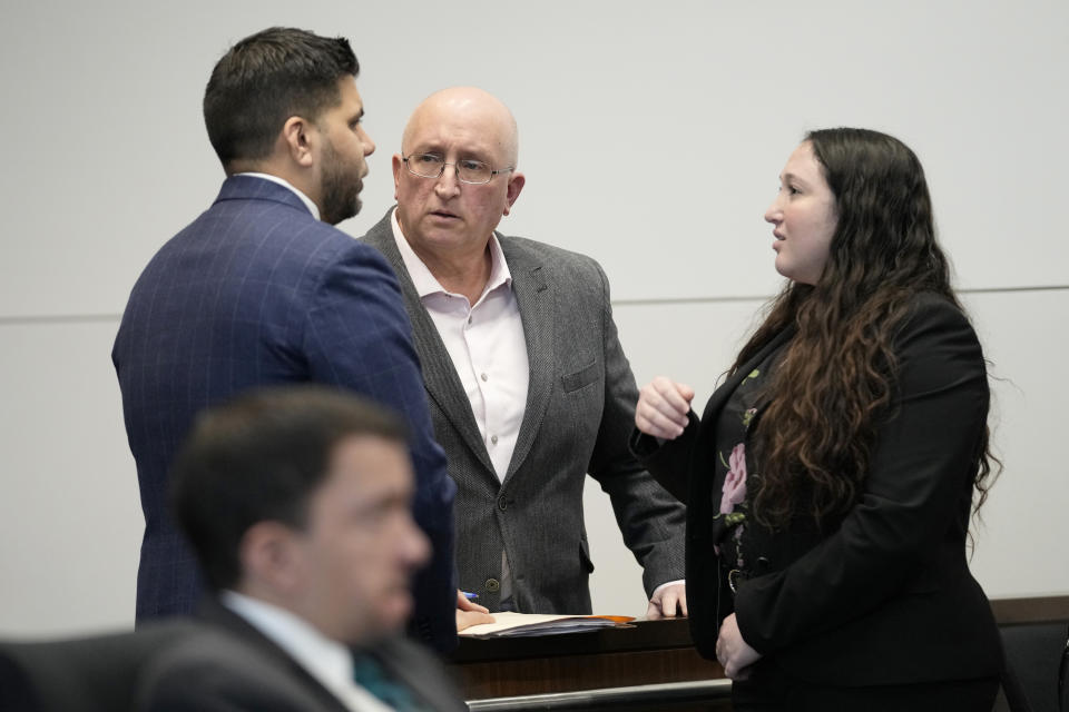 Robert E. Crimo Jr., center, father of Robert Crimo III, talks with his attorneys as they wait for court to begin before Judge George D. Strickland at the Lake County, Ill., Courthouse Thursday, Jan. 26, 2023, in Waukegan, Ill. Crimo Jr., faces seven counts of felony reckless conduct for signing the application for his son's firearm owners ID card in December of 2019. (AP Photo/Nam Y. Huh, Pool)