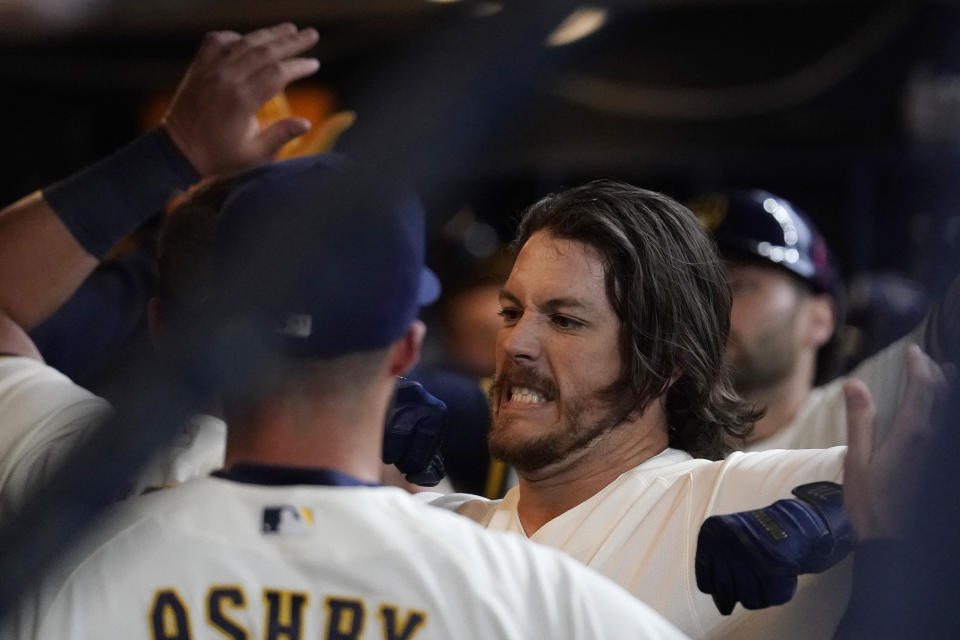 Milwaukee Brewers' Brian Anderson is congratulated in the dugout after hitting a two-run home run during the fourth inning of a baseball game against the New York Mets Monday, April 3, 2023, in Milwaukee. (AP Photo/Aaron Gash)