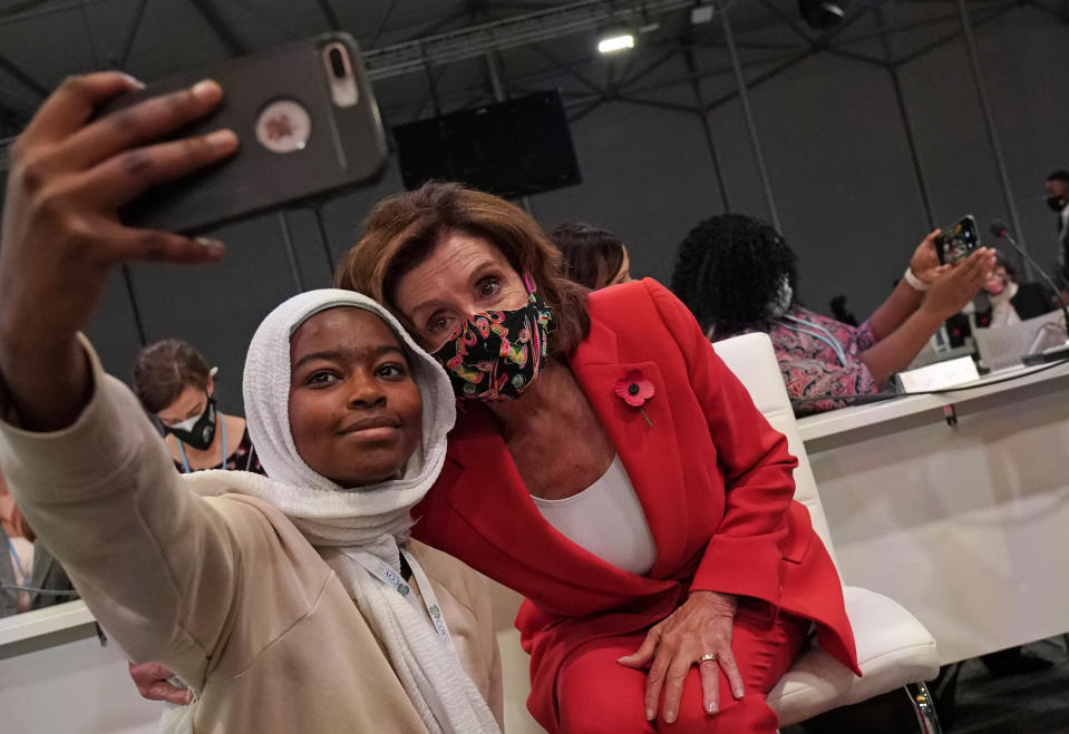 A delegate has selfie taken with Speaker of the United States House of Representatives Nancy Pelosi at a session inside the venue of the COP26 U.N. Climate Summit in Glasgow, Scotland, Tuesday, Nov. 9, 2021. The U.N. climate summit in Glasgow has entered it's second week as leaders from around the world, are gathering in Scotland's biggest city, to lay out their vision for addressing the common challenge of global warming. (AP Photo/Alberto Pezzali)