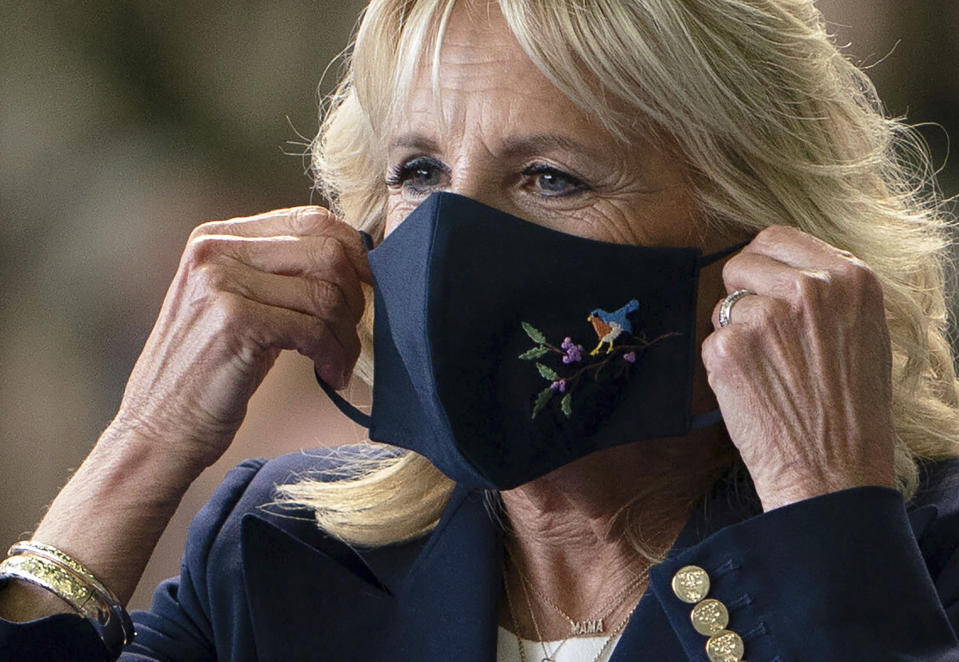 FILE - First lady Jill Biden adjusts her face mask after addressing U.S. Air Force personnel at RAF Mildenhall in Suffolk, England, ahead of the G7 summit in Cornwall, on June 9, 2021. (Joe Giddens/Pool via AP, File)