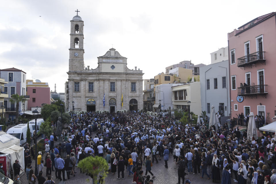 People gather outside the Metropolitan church ahead of the funeral service for the late Greek composer Mikis Theodorakis, in Chania, Crete island, Greece, Thursday, Sept. 9 2021. Theodorakis died Thursday, Sept. 2, 2021 at 96. He penned a wide range of work, from somber symphonies to popular TV and film scores, including for “Serpico” and “Zorba the Greek.” He is also remembered for his opposition to the military junta that ruled Greece from 1967-1974, when he was persecuted and jailed and his music outlawed. (AP Photo/Harry Nakos)