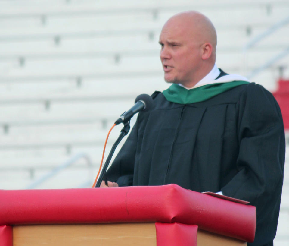 In this May 23, 2019 photo, Principal Kenny DeMoss gives closing remarks during Parkersburg High School's 2019 graduation ceremony, in Parkersburg, W.Va. The West Virginia principal accused of plagiarizing Ashton Kutcher in the address to his school's graduating class says he didn't mean to use someone else's work. DeMoss has issued a statement saying he should have cited his sources in the speech, but asserted the ideas were his own. (Michael Erb/News and Sentinel via AP)