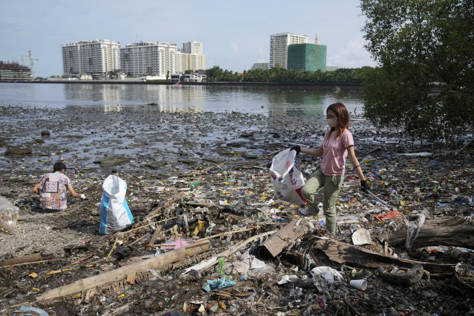 FILE - Volunteers pick up garbage along a polluted coastal area in Metro Manila, Philippines Friday, Sept. 16, 2022. Negotiators from around the world gather at UNESCO in Paris on Monday, May 29, 2023 for a second round of talks aiming toward a global treaty on fighting plastic pollution in 2024. (AP Photo/Aaron Favila, File)
