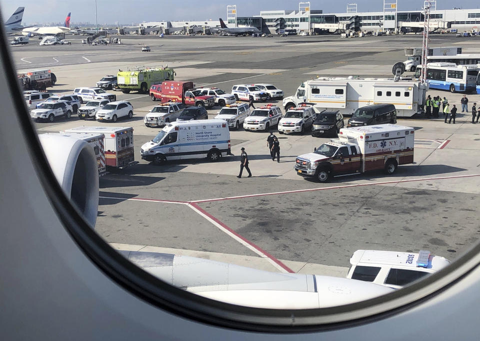 Emergency response crews gather outside a plane at New York's Kennedy Airport amid reports of ill passengers aboard a flight from Dubai on Wednesday, Sept. 5, 2018. (Larry Coben via AP)