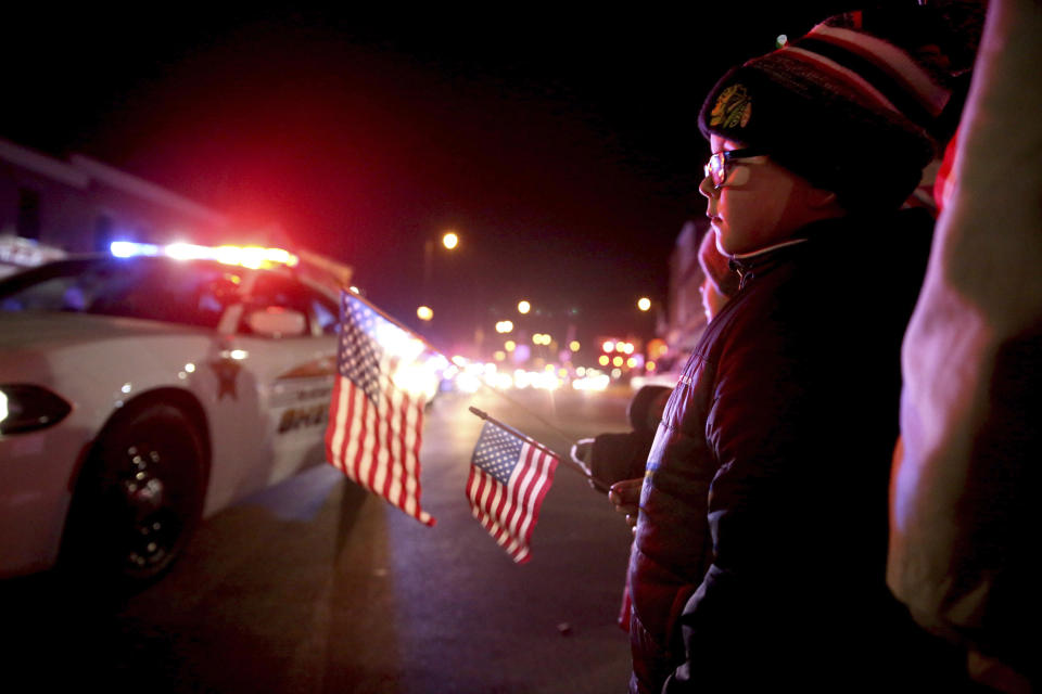 People line the street for the procession from a Rockford, Ill. hospital to the funeral home Friday, March 8, 2019, in Huntley, Ill., for fallen McHenry County Sheriff's Deputy Jacob Keltner. An Illinois man faces federal murder charges in the shooting death of the sheriff's deputy that led to an hourslong standoff with police along an interstate. (Patrick Kunzer/Daily Herald via AP)