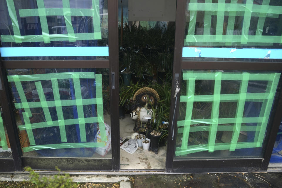 A pottery figurine is placed inside a flower shop as Typhoon Hagibis approaches in town of Kiho, Mie Prefecture, Japan Friday, Oct. 11, 2019. A powerful typhoon was forecast to bring 2 feet of rain and damaging winds to the Tokyo area this weekend, and Japan's government warned people Friday to stockpile supplies and evacuate before it's too dangerous. (AP Photo/Toru Hanai)