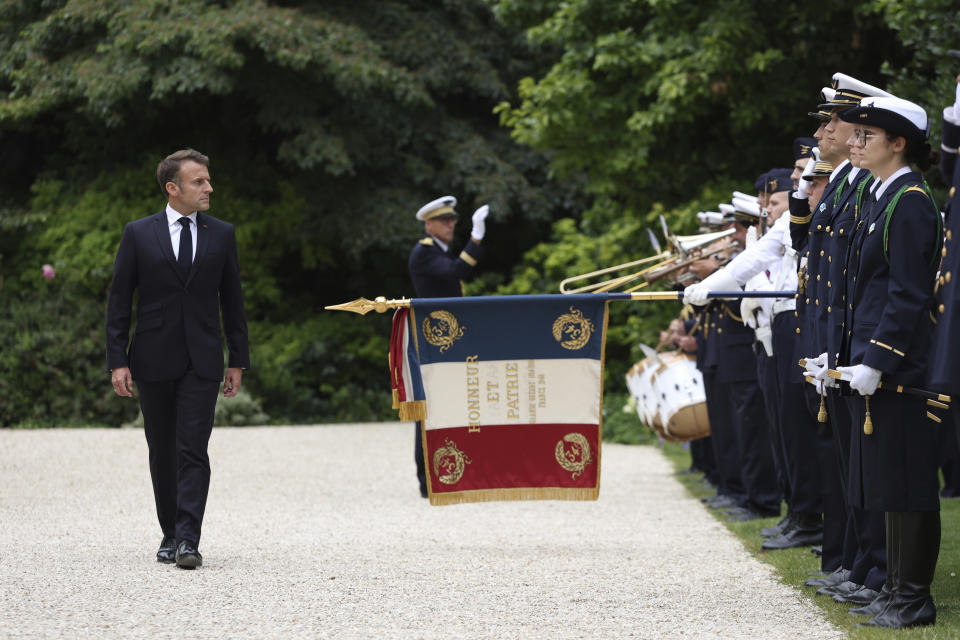 FILE - French President Emmanuel Macron reviews troops that will take part to the Bastille Day parade, Tuesday, July 2, 2024 in Paris. High-stakes legislative elections this Sunday will almost certainly impact the French leader's sway in the fields of defense and foreign affairs, quite possibly diminishing his role as an energetic and influential figure in European and world affairs and as one of Ukraine's primary backers in the war against Russia, say retired French military officers and analysts of France's defense and foreign policies (AP Photo/Aurelien Morissard, Pool, File)