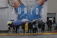 People wait for the metro to open amid rain brought by Tropical Storm Franklin in Santo Domingo, Dominican Republic, early Wednesday, Aug. 23, 2023. (AP Photo/Ricardo Hernandez)