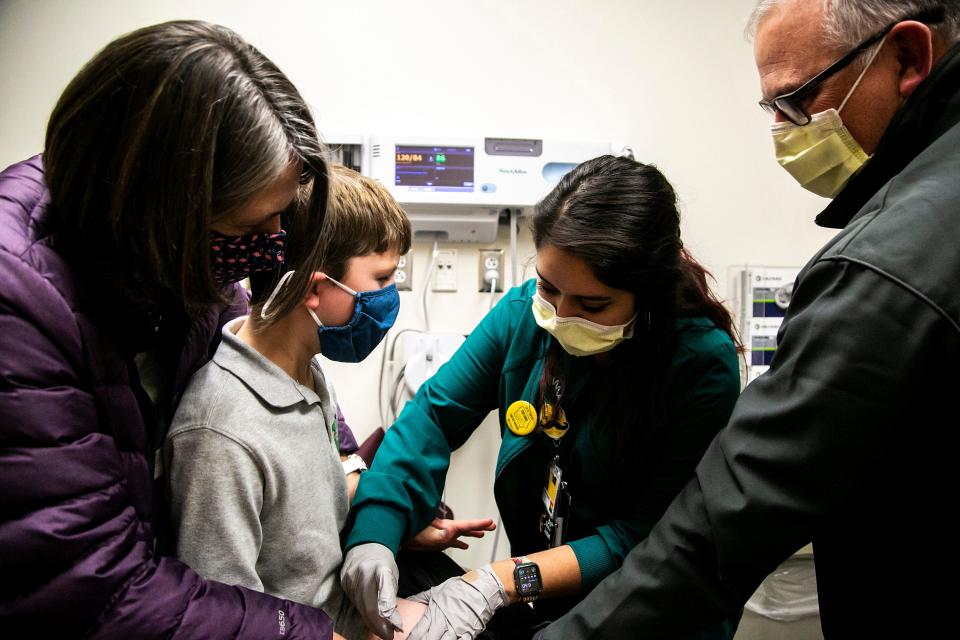 Luke Quinlan, 8, receives a dose of the Pfizer pediatric COVID-19 vaccine from medical assistant Consuelo Valladolid on the first day of a clinic with the University of Iowa Hospitals & Clinics as his parents Sarah, left, and Jeff, comfort him