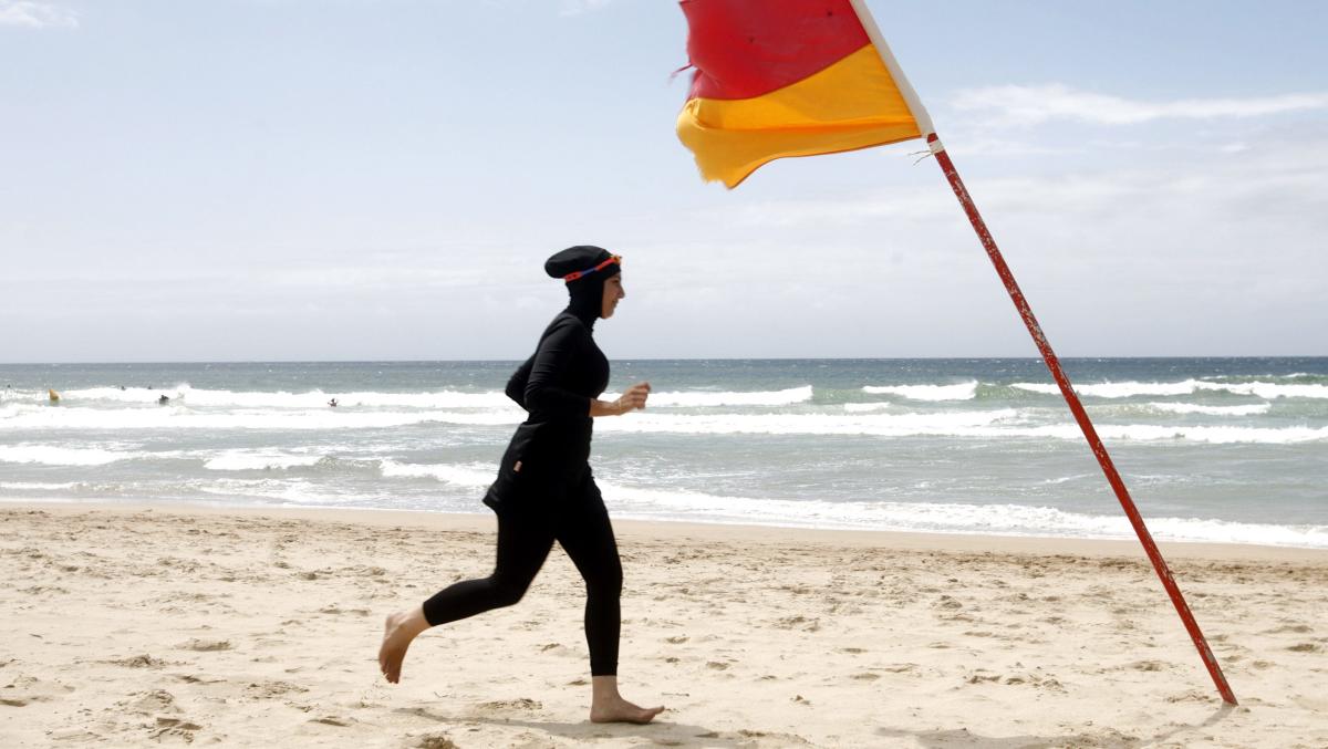 Photos show French police making a woman take off her blouse on a beach  where burkinis are banned