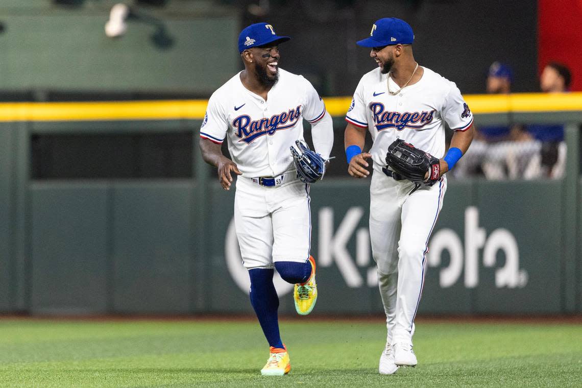 Rangers outfielder Adolis Garcia (53) shares a laugh with his teammate Leody Taveras (3) after finishing the first inning during the Texas Rangers season opener against the Chicago Cubs at Globe Life Field on Thursday, March 28, 2024.