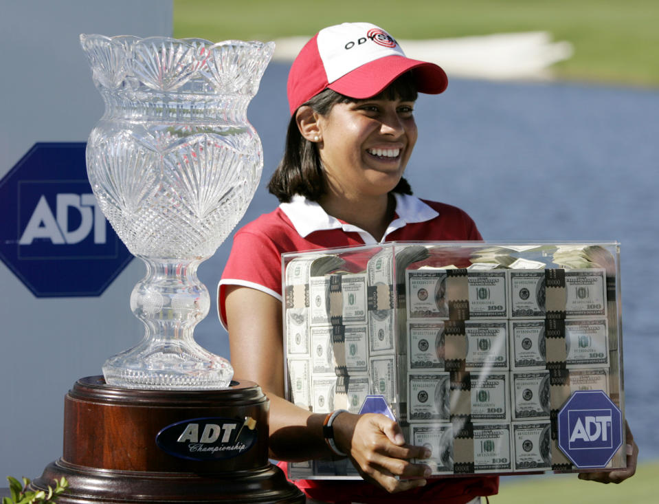 FILE - In this Nov. 19, 2006 file photo Julieta Granada, of Paraguay, stands next to her trophy as she holds a box of money after winning the LPGA ADT Championship at the Trump International Golf Club in West Palm Beach, Fla. The format this year allows any of the 60 players to win the $1.5 million prize by winning the CME Group Tour Championship. (AP Photo/Lynne Sladky, file)