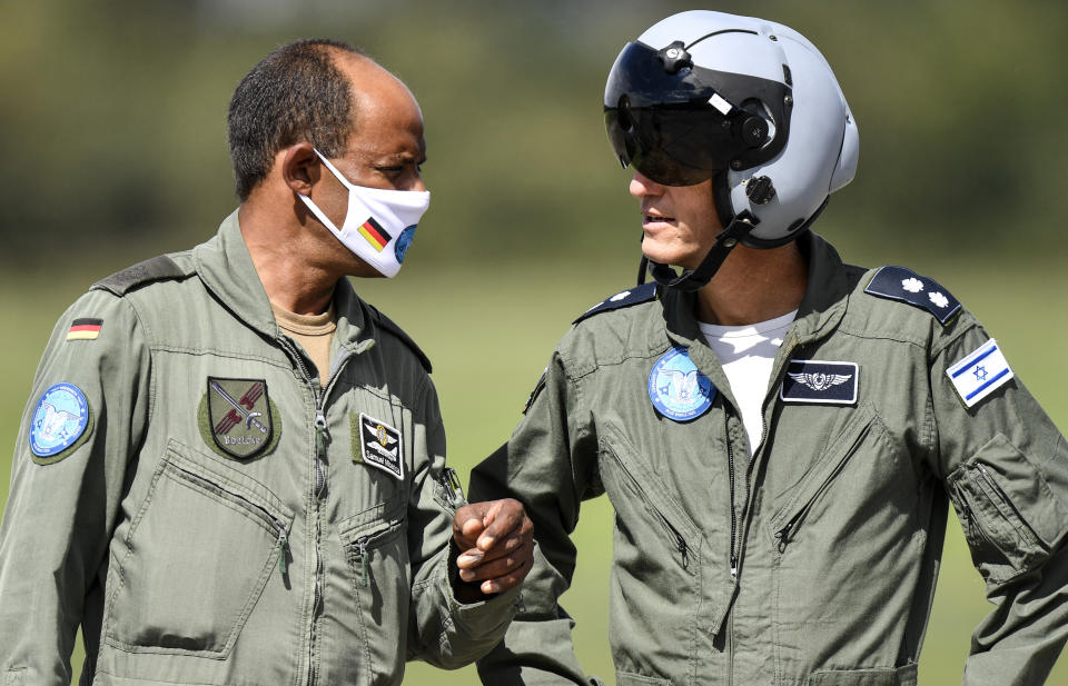 German Lieutenant colonel Samuel Mbassa, left, talks with a pilot from Israel, right, at the airbase in Noervenich, Germany, Thursday, Aug. 20, 2020. Pilots from Israel and Germany will fly together the next two weeks during the first joint military Air Force exercises between the two nations in Germany. (AP Photo/Martin Meissner)