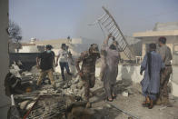 Rescue work is in progress at the site of a plane crash in Karachi, Pakistan, Friday, May 22, 2020. An aviation official says a passenger plane belonging to state-run Pakistan International Airlines carrying more than 100 passengers and crew has crashed near the southern port city of Karachi. There were no immediate reports on the number of casualties. (AP Photo/Fareed Khan)