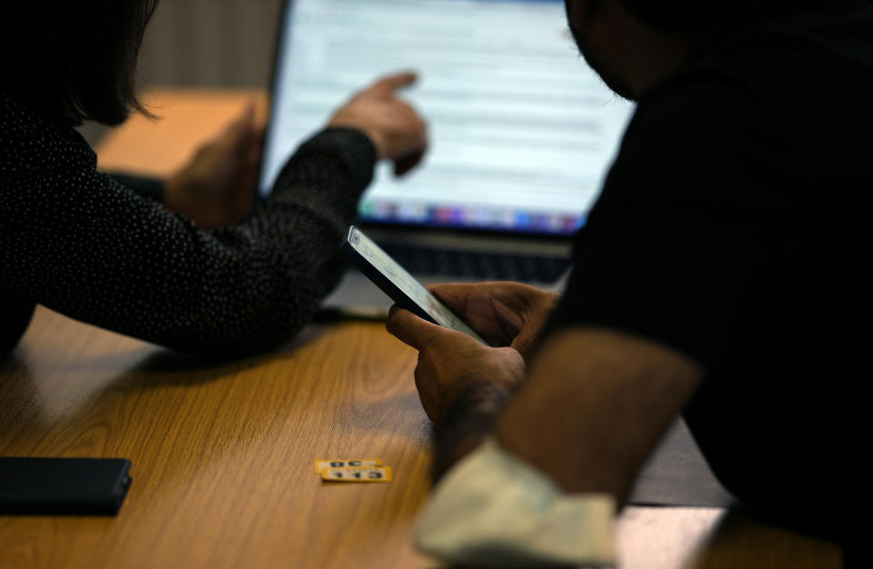 Volunteers help Afghan refugees and British citizens who have relatives and family in Afghanistan, who they will try to locate and bring out of the country, at the Afghanistan and Central Asia Association in London, Friday, Aug. 27, 2021.(AP Photo/Alastair Grant)