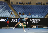 Spain's Garbine Muguruza serves to Britain's Johanna Konta as a spectator sleeps in the stands during their second round match at the Australian Open tennis championships in Melbourne, Australia, Friday, Jan. 18, 2019. (AP Photo/Mark Baker)