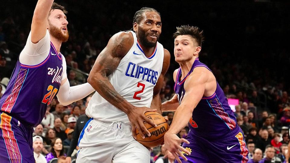 Los Angeles Clippers forward Kawhi Leonard (2) drives past Phoenix Suns guard Grayson Allen, right, and center Jusuf Nurkic (20) during the first half of an NBA basketball game Wednesday, Jan. 3, 2024, in Phoenix.