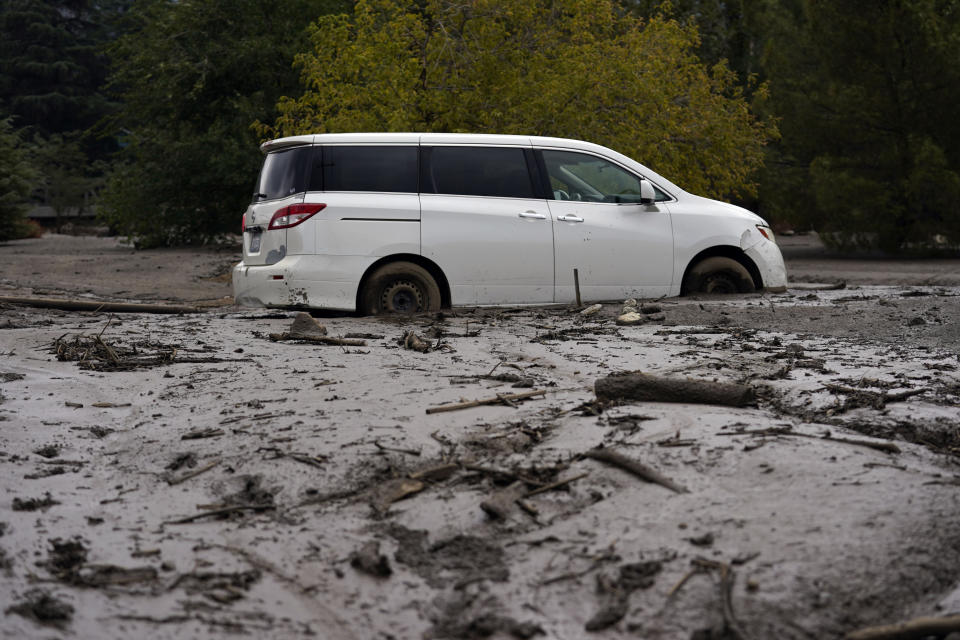 A vehicle is stuck in the mud in the aftermath of a mudslide Tuesday, Sept. 13, 2022, in Oak Glen, Calif. Cleanup efforts and damage assessments are underway east of Los Angeles after heavy rains unleashed mudslides in a mountain area scorched by a wildfire two years ago. (AP Photo/Marcio Jose Sanchez)